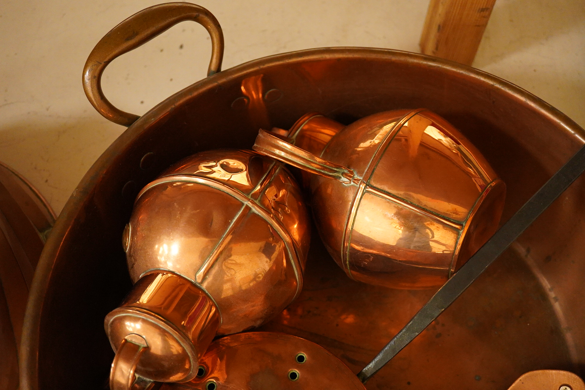 Five copper items including a large jelly mould, a two handled pan, two jugs and a chestnut roaster, pan 41cm diameter. Condition - fair to good